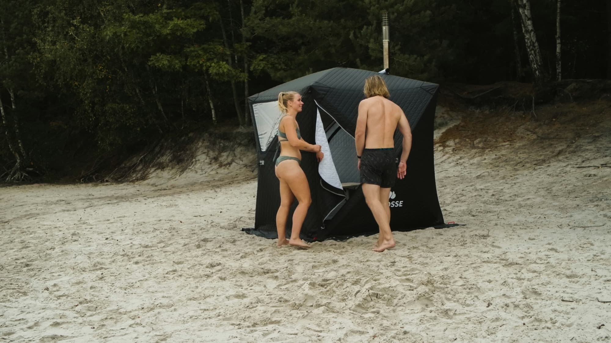 Twee mensen bij de saunatent op het strand