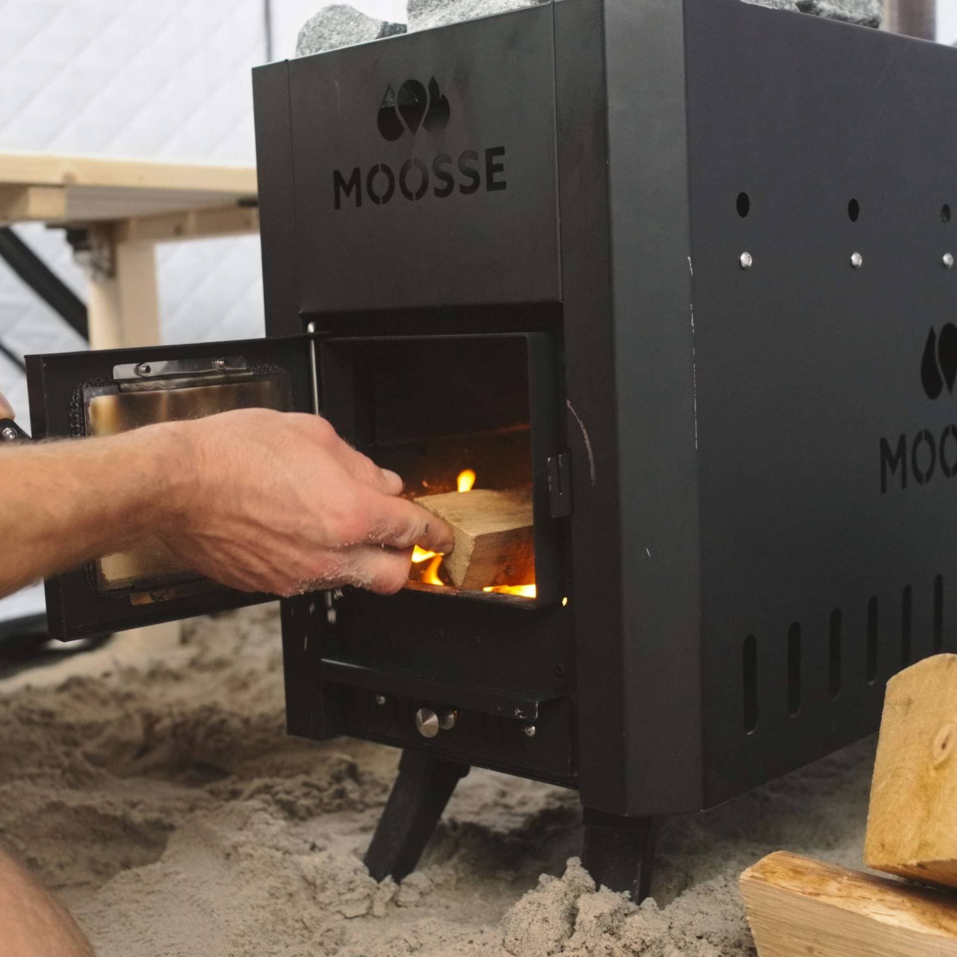 Hout wordt in de kachel gelegd