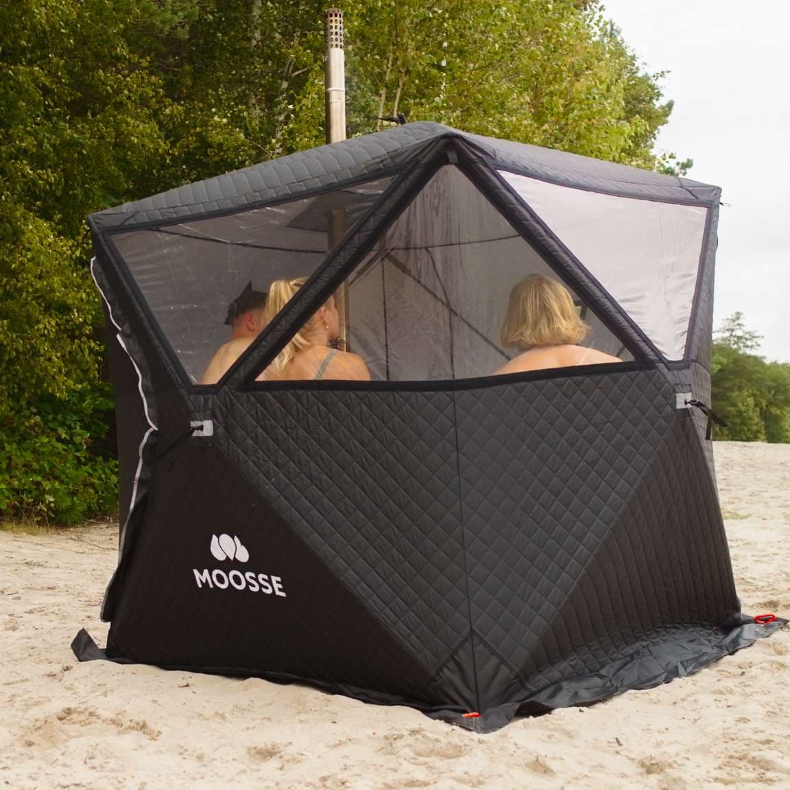 Saunatent van MOOSSE op het strand met mensen erin